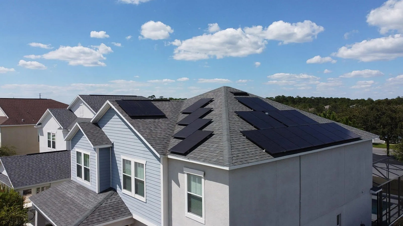 Aerial view of a rear-roof solar array over a home with a pool